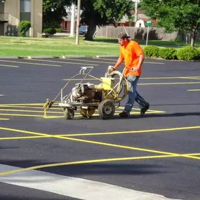 man painting parking lot stripes