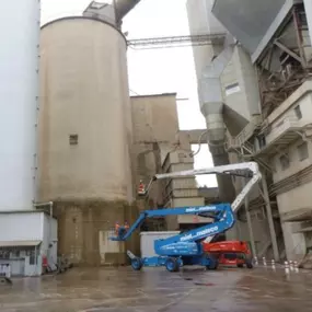 Panoramic view of cement plant with four silos undergoing robotic inspection