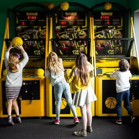 Kids aiming at basketball net arcade game