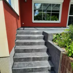 Treppe und Terasse mit neu verlegten grauen Fliesen