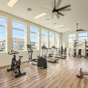 Gym with cardio equipment and a large window