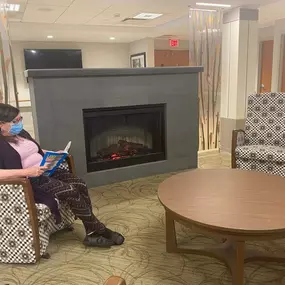 Shaker Place Rehabilitation and Nursing Center Resident reading in common area