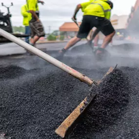 plm paving employees raking asphalt