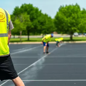 PLM Paving employees line striping a parking lot
