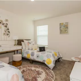 Cozy bedroom with two twin beds, colorful bedding, and a decorative wall map