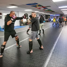 Spacious open-floor training area equipped for both strength and functional training, creating a versatile environment for private coaching, kickboxing drills, and dynamic fitness routines.