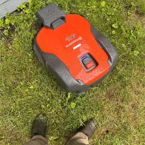 A person stands by a red and robotic lawn mower, highlighting gardening and outdoor maintenance innovation.
#lawnmower #whisprinnovation