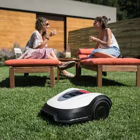 Two women sit comfortably in lawn chairs, sharing a light moment with a robotic mower beside them.
#roboticmowerservices #roboticmowerlakestevens