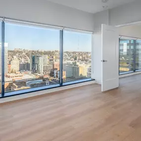 A room with a view of a cityscape through large windows.