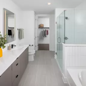 Spacious bathroom with a double vanity and glass-enclosed shower.