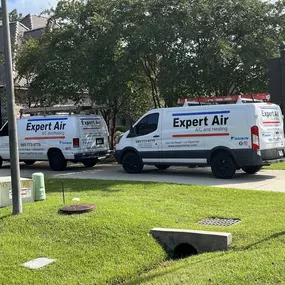 Expert Air A/C and Heating vans outside of a house