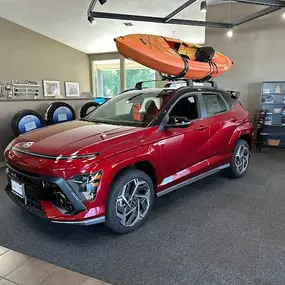 Side profile of a Hyundai SUV with a boat strapped to the roof rails