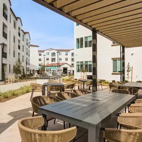 A patio with a table and chairs is surrounded by buildings.