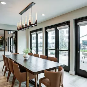 A modern dining room with a long table and chairs.