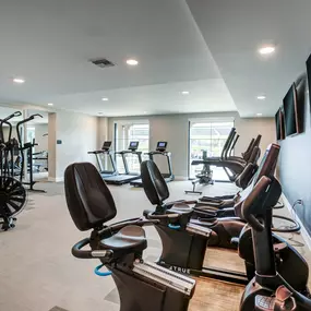 A gym with a variety of exercise equipment including stationary bikes and weight machines.