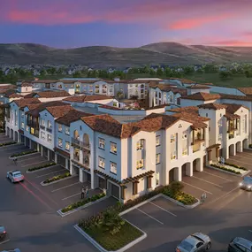 A large hotel with a parking lot in front of it.