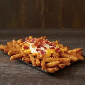 Our Famous Seasoned Fries topped with cheese, ranch and crispy bacon.