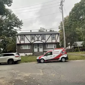 zhumas construction van parked outside of a tudor-style house