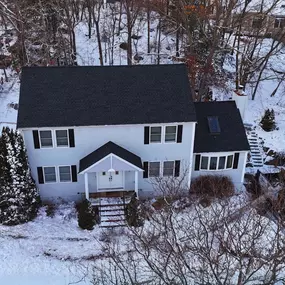 aerial view of a house and finished roof, with snow on the ground