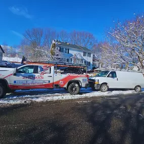 zhumas construction truck parked in front of house, with snow on the ground