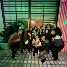 group picture of a team in an office interior with green lighting