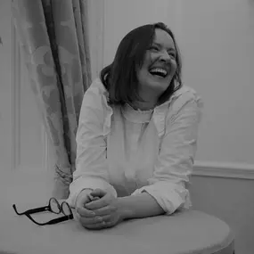 Lisa Powell, founder of Fortis Education, is captured in a candid moment, laughing and radiating joy. Her vibrant energy reflects her dedication to nurturing a love for learning and creating a positive atmosphere.