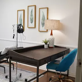 brown table with lamp and blue chair