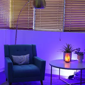 blue chair with small lamp and yellow blinds