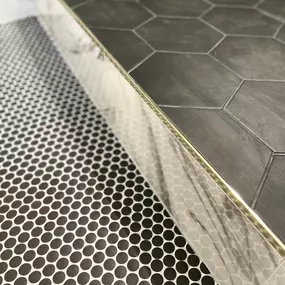 Bold choices meet expert design in this standout bathroom remodeling project by Ledezma Remodeling. The pairing of oversized black hex tiles with a classic penny tile floor brings a unique visual rhythm to the space, balancing modern drama with timeless appeal. Every line, edge, and material was chosen with intention, proving that great design lives in the details.