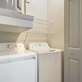 Full-size washer and dryer included with wire shelves at Camden Leander apartments in Leander, Tx