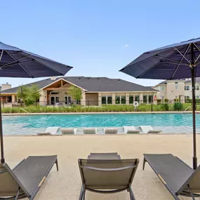 View of the resort-style pool and clubhouse from the sundeck at Camden Leander apartments in Leander, Tx