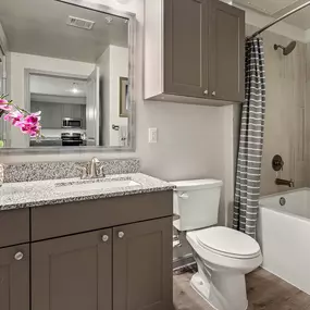 Bathroom with modern tile surrounded bathtub and quartz countertops at Camden Leander apartments in Leander, Tx