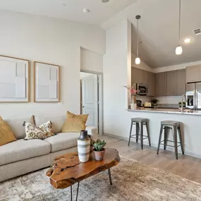 Second-floor living and kitchen with vaulted ceilings and wood-style flooring at Camden Leander apartments in Leander, Tx