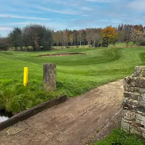 A pleasant par 3, teeing from an elevated tee you will need to carry difficult rough and a small ditch that runs across the fairway. Playing into a large tear shaped green that is uncaptured by a bank.