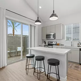 an open kitchen with a island and three stools