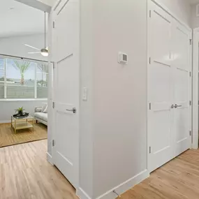 an open living room and dining room with white walls and wood floors