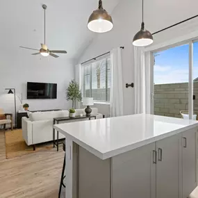 a kitchen island in a living room with a couch and a tv