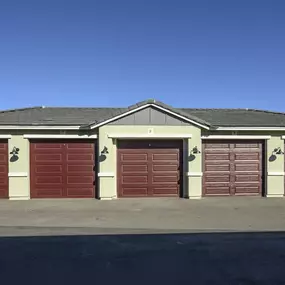 a garage with red doors in front of a house