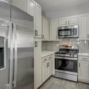A modern kitchen with a stainless steel refrigerator and oven