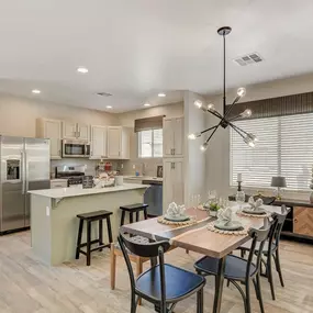 A modern kitchen with a dining table set for four