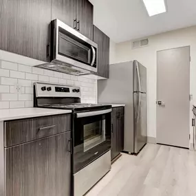 A modern kitchen with a stove top oven and microwave above it