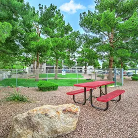 Picnic table and bench in a park with trees