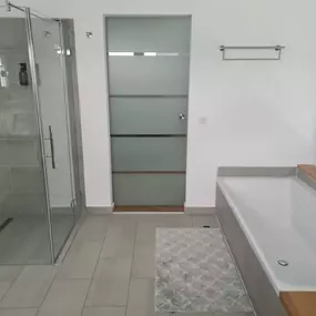 Das Bild zeigt ein vollständig saniertes Badezimmer mit neuer Fliesengestaltung, moderner Ausstattung und klarer Raumaufteilung. Die Arbeiten wurden von Schnelle Bau in hochwertiger Ausführung umgesetzt.