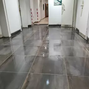 Das Bild zeigt die präzise Verlegung großformatiger Fliesen durch einen Fliesenleger. Solche Formate erfordern fachgerechte Planung und exakte Ausführung – typisch für moderne Badezimmer und Wohnbereiche.