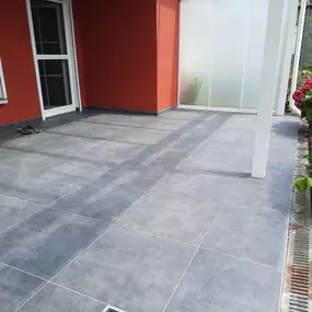 Das Bild zeigt eine modern gestaltete Terrasse mit großformatigen Bodenfliesen. Die Fliesen wurden fachgerecht im Außenbereich verlegt und sorgen für eine klare, hochwertige Optik mit pflegeleichter Oberfläche.