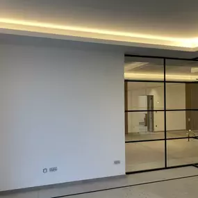 Das Bild zeigt ein modernisiertes Großraumbüro nach kompletter Sanierung. Der Fokus liegt auf den frisch gestrichenen Wand- und Deckenflächen. Die Räume wirken hell, sauber und klar strukturiert.