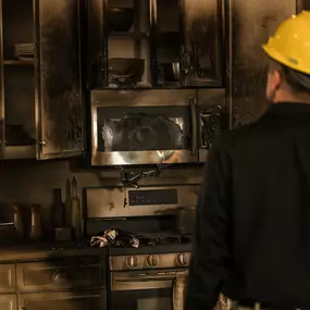 ServiceMaster technician examining a fire-damaged kitchen