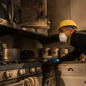 ServiceMaster technician examining a fire-damaged kitchen