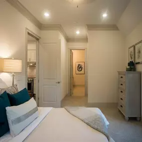 A modern bedroom at Tindall Park at SouthPark Apartments with a large bed and soft lighting.