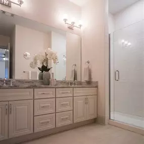 A stylish bathroom at Tindall Park at SouthPark Apartments featuring a sleek sink and mirror.